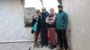 Maryna Snizhinska and her relatives stand in their destroyed house in the village of Dolyna, eastern Ukraine, on October 5.