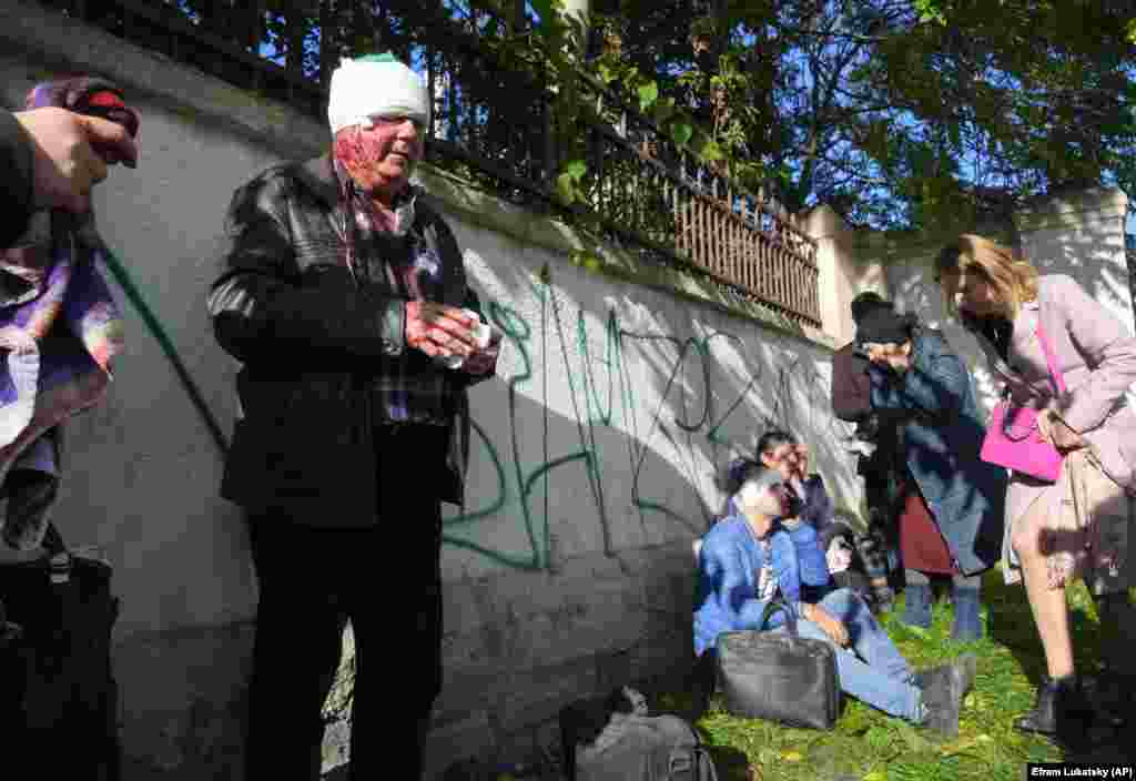 Injured people are tended to after a missile strike in central Kyiv. Kyiv Mayor Vitali Klitschko said Russian shelling hit buildings, including some that are part of the Ukrainian capital&#39;s &quot;critical infrastructure.&quot;