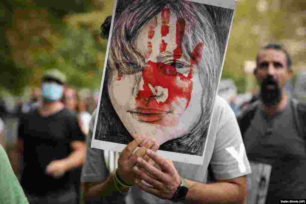 A man holds up a placard during a protest in Bucharest on October 1 against the death of Iranian Mahsa Amini, who died while in police custody after being arrested by Iran&#39;s morality police for allegedly violating its strictly enforced dress code.