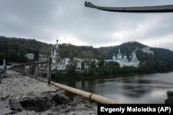 Biserica din Munții Sfinți, o mănăstire ortodoxă, este văzută de pe un pod distrus peste râul Siverskiy Doneț în orașul Svyatohirsk, în octombrie 2022.