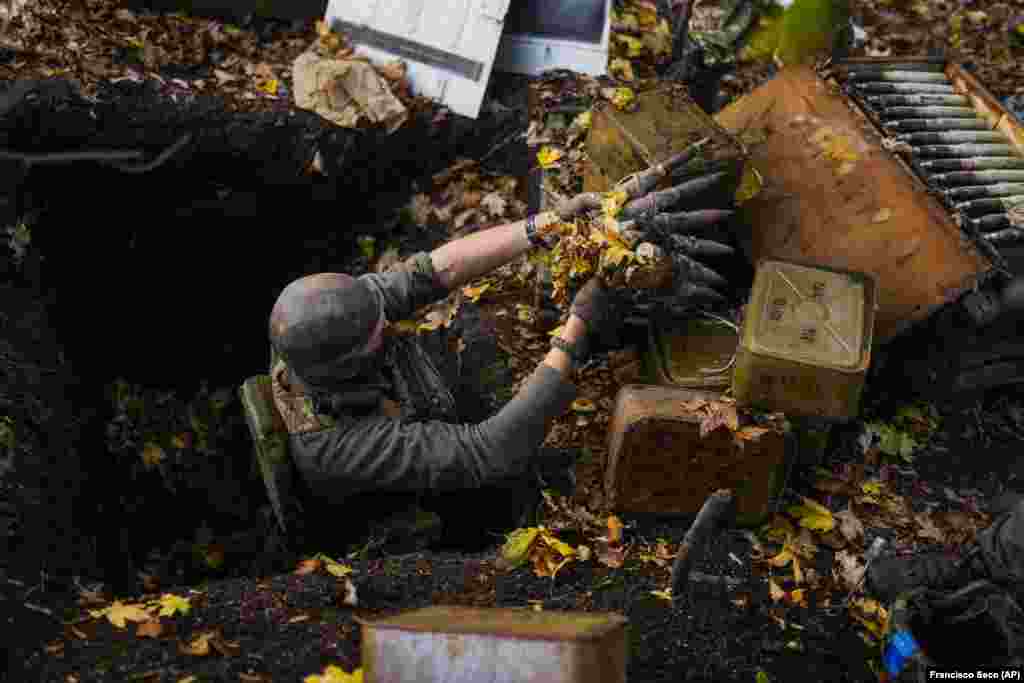 A Ukrainian territorial defense deminer gathers decaying ammunition from a former Russian position near Hrakove village, in the Kharkiv region of eastern Ukraine on October 13.&nbsp;