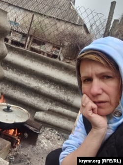 Алла Веселовська, готує їжу на багатті під час російської окупації. Високопілля