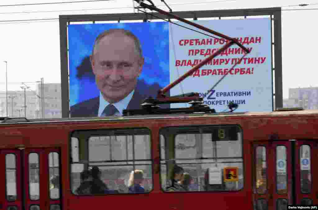People in a tram in Belgrade pass a big screen showing Russian President Vladimir Putin wishing him a happy birthday from his &quot;Serb brethren!&quot; on October 7.&nbsp;
