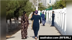 Женщины в Туркменистане на фоне наблюдающих сотрудников полиции. Иллюстративное фото.