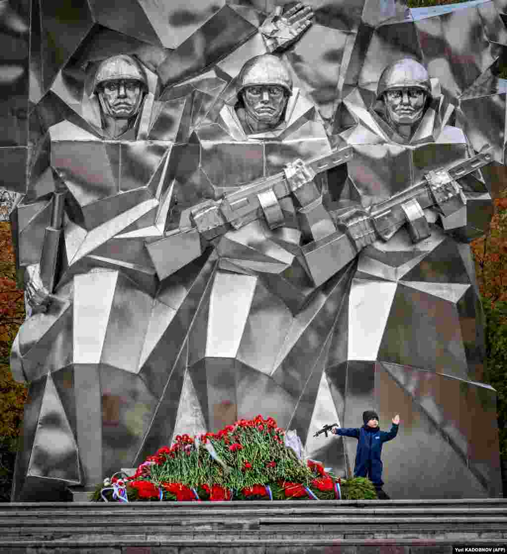 A boy holds a toy machine gun as he stands next to a World War II monument in the Russian town of Podolsk, some 40 kilometers outside Moscow.