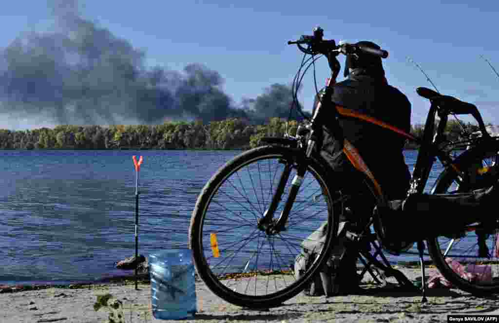 Un bărbat prinde pește pe malul râului Nipru, la scurt timp după ce mai multe rachete rusești au lovit capitala Ucrainei, Kiev, pe 10 octombrie.