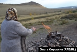 A woman in Bystraya warms herself by a natural-gas vent. (file photo)