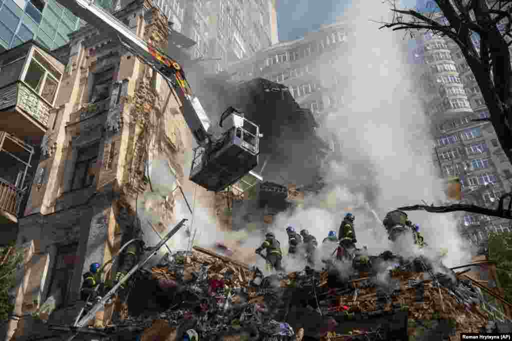 Firefighters work after a drone attack on buildings in Kyiv on October 17.