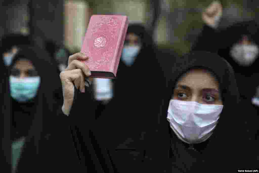 A protester holds a copy of the Koran during a demonstration to condemn planned Koran burnings by a right-wing group in Sweden, in front of the Swedish Embassy in Tehran.