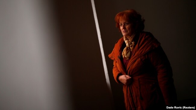 Nusreta Sivac, a Bosnian War rape victim, looks through a window in one of several camps where she was detained, in Trnopolje near Prijedor, Bosnia-Herzegovina. (file photo)