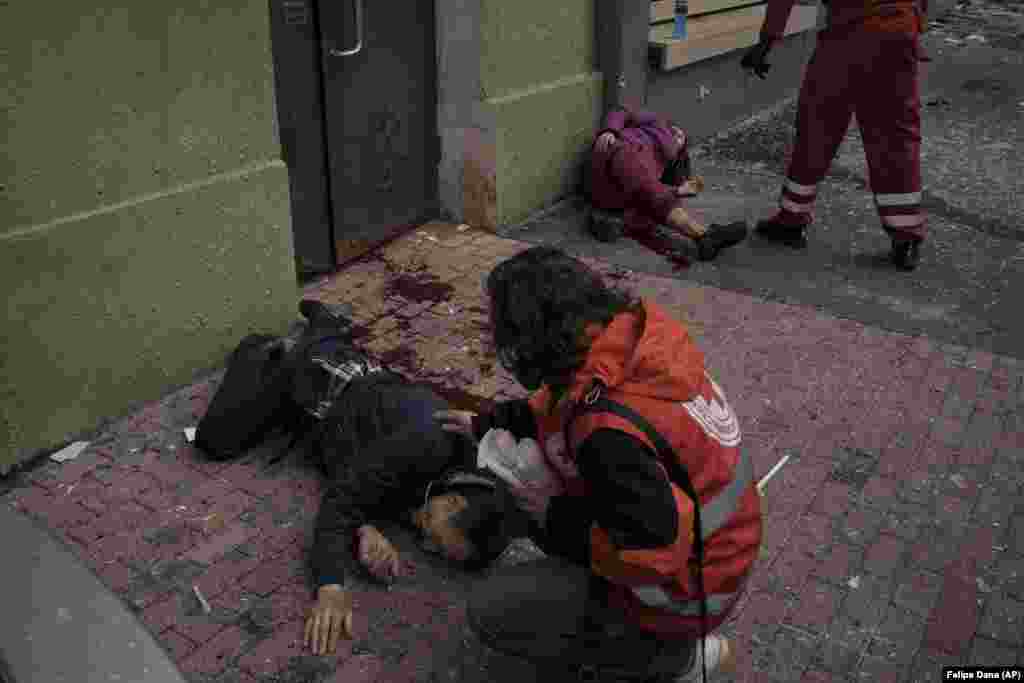 A bombázásokban megsebesült civileket látnak el a mentőalakulatok Harkivban április 17-én