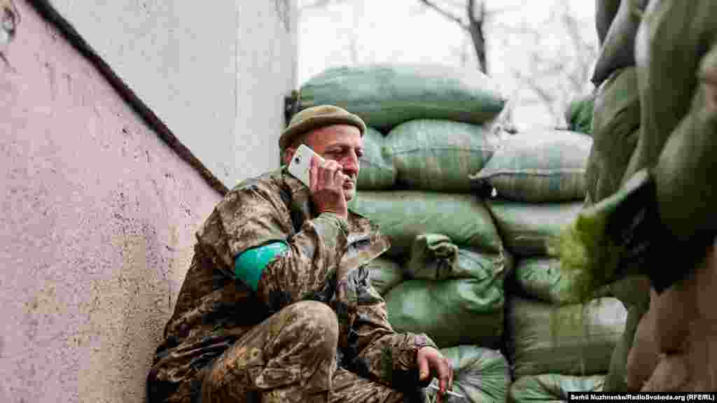 Військовий спілкується по телефону з близькими, передові позиці в Сєвєродонецьку, 16 квітня 2022 року&nbsp;