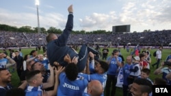 Футболисти и фенове на "Левски" хвърлят във въздуха треньора си Станимир Стоилов-Мъри на фона на препълнения сектор "Б".