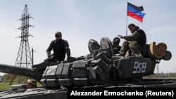 Soldiers of the Moscow-backed separatist forces ride a tank near Novoazovsk in the Donetsk region.