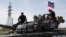Soldiers of the Moscow-backed separatist forces ride a tank near Novoazovsk in the Donetsk region.