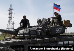 Новоазовск қаласында ресейлік әскери танктің үстінде отырған "ДХР" сепаратистік құрылымының сарбаздары. Донецк облысы, Украина, 6 мамыр 2022 жыл.