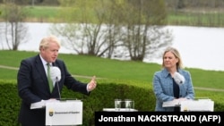 Premierul britanic Boris Johnson și șefa guvernului Suediei, Magdalena Andersson, vorbind la o conferință de presă după discuții la reședința lui Andersson din Harpsund, pe 11 mai 2022, după semnarea unui acord privind garanții de securitate.