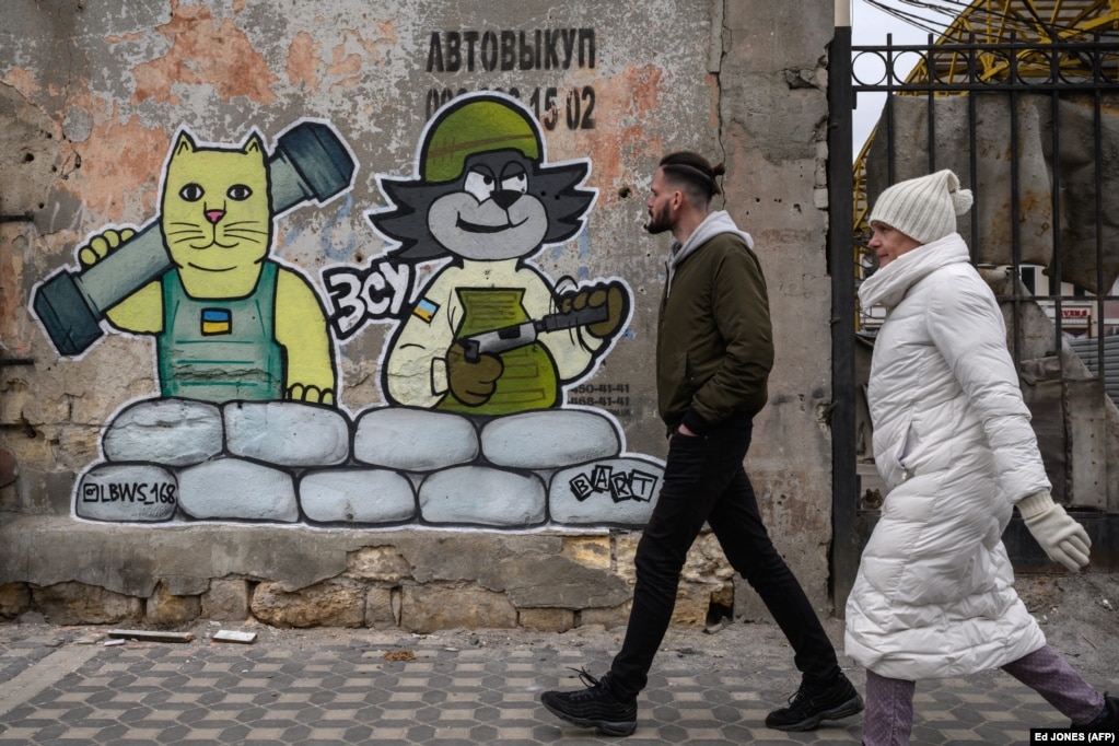 Ky mural, i krijuar nga grupi LBWS, në qytetin-port ukrainas Odesa, është paraqitur me elemente fëmijërore, teksa portretizon seriozitetin e luftës.
