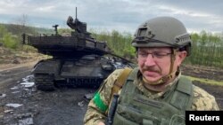 Украински войник до унищожен руски танк