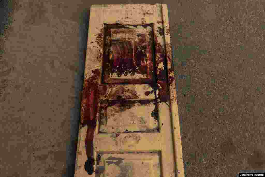 Vérfoltok egy hordágynak használt faajtón a bahmuti kórház sürgősségi osztályán