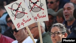 Armenia - A protester holds posters demanding Prime Minister Nikol Pashinian's resignation, May 13, 2022.