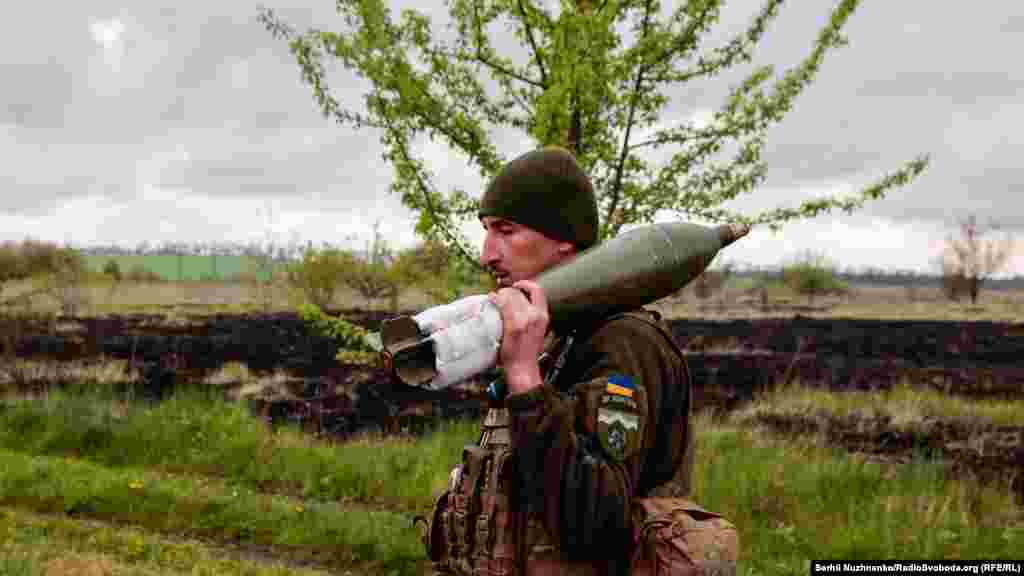 A mortarman carries a 120-mm round to a new position. Each round weight 14.8 kilograms.