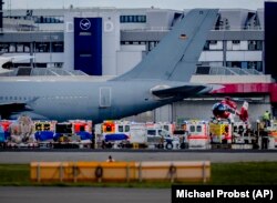 Mentőautók sebesült ukrán katonákra várnak a frankfurti repülőtéren 2022. május 12-én