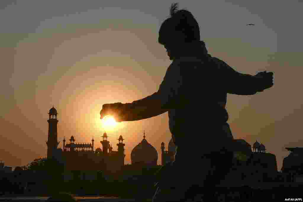 &nbsp;A boy plays near the historic Badshahi Mosque at sunset in Lahore, Pakistan. (AFP/Arif Ali)