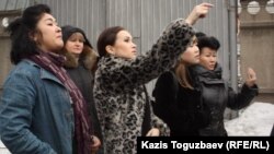 Группа гражданских активистов с тыльной стороны тюрьмы КНБ приветствует содержащегося в ней Игоря Винявского, главного редактора газеты "Взгляд". Алматы, 10 марта 2012 года.