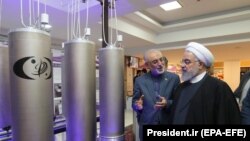 Iranian President Hassan Rohani and head of Iran's nuclear technology organization Ali Akbar Salehi (2-R) visit a nuclear facility during the National Nuclear Technology Day in Tehran, April 9, 2019