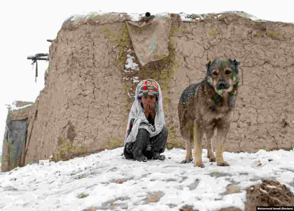 Një fëmijë afgan, i cili është i zhvendosur, qëndron jashtë strehimores ku ai banon në Kabul.(Reuters/Mohammad Ismail)