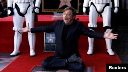 Mark Hamill színész a Hollywood Walk of Fame-en leleplezett csillagán térdel 2018. március 8-án