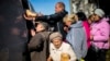 Locals line up to receive food and everyday necessities given by Ukrainian volunteers in Izyum, where residents have been living without gas, electricity, or running water supply since the beginning of September. 