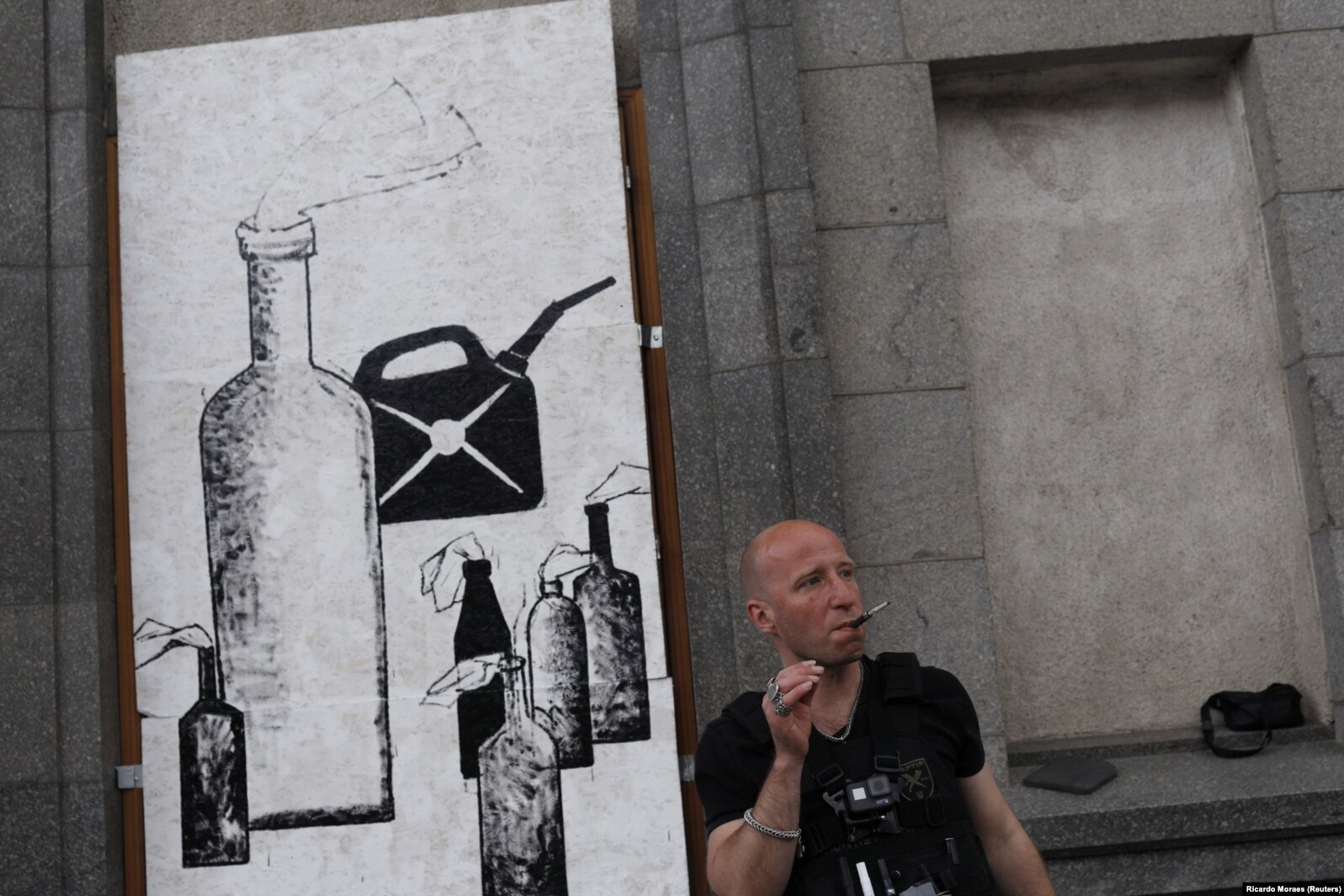 Artisti Zinkivskiy qëndron pranë muralit të tij ku shkruan: "Mikpritje djallëzore".