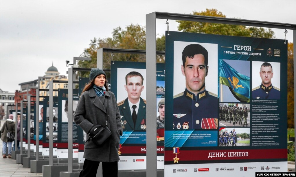 Россиянка стоит у выставки фото солдат, воевавших во время российского неспровоцированного вторжения в Украину, под названием &laquo;Герои с вечным русским сердцем&raquo; в Москве, 17 октября.