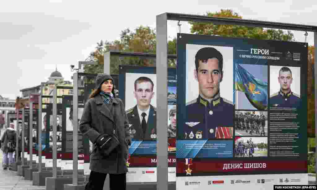 A Russian woman stands by an exhibit of soldiers who fought in Ukraine called &quot;Heroes With An Eternal Russian Heart&quot; in Moscow on October 17.