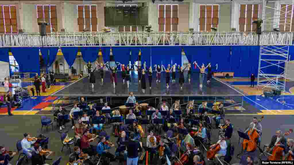 Balerinat dhe balerinët e Baletit Kombëtar të Kosovës duke bërë prova në një skenë të improvizuar në sallën &quot;1 Tetori&quot;.