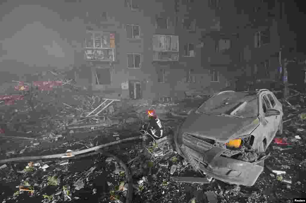 Un pompier se odihnește pentru scurt timp în dreptul unei clădiri rezidențiale grav avariate de un atac cu rachete rusești în Zaporojie, Ucraina, 10 octombrie 2022.