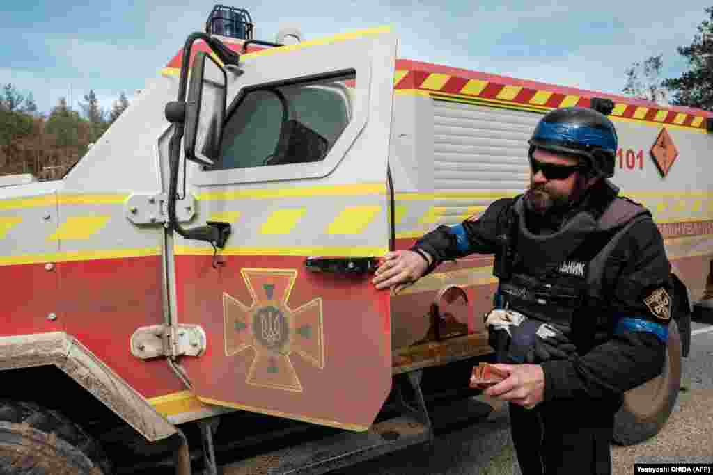 An officer with the Ukrainian National Police&#39;s demining team prepares to deal with mines and other explosives near the liberated town of Lyman. Human Rights Watch (HRW) says Russia is causing casualties and suffering among civilians in its war against Ukraine by using antipersonnel land mines that have been banned internationally.