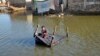 A girl sits on a cot as she crosses a flooded street in Balochistan Province on October 4.