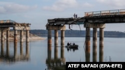 Civilek kelnek át a Sziverszkij Donyec folyón a felszabadított Sztarij Szaltiv városában, Harkivtól keletre. Becslések szerint Ukrajnának a következő tíz évben több száz milliárd dollárra lesz szüksége a megsemmisített gazdaság és infrastruktúra újjáépítéséhez