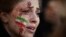 A demonstrator with an Iranian flag and bloody hands painted on her face attends a rally in support of the Iranian protests in Paris.