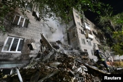 Спасатель работает на месте жилого дома, сильно пострадавшего от российского ракетного удара. Запорожье, 10 октября 2022 года
