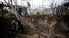 Investigators inspect a crater left by a Russian missile strike at an electrical transformer facility in Kharkiv in September 2022. 