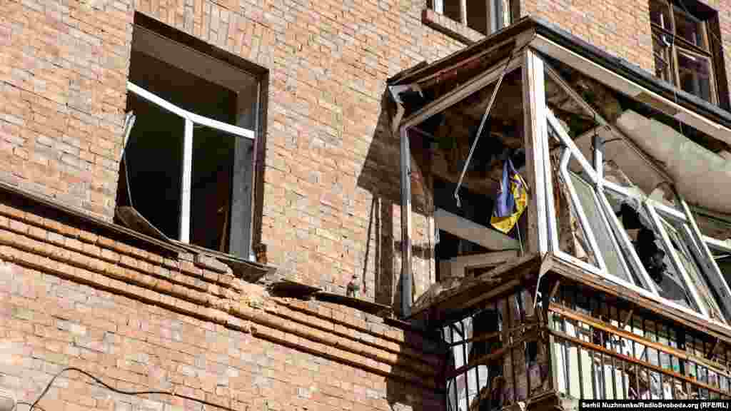 Український прапор на балконі квартири, яка зазнала руйнування внаслідок ракетного обстрілу в Шевченківському районі Києва