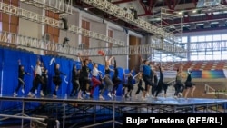 Balerinat dhe balerinët e Baletit Kombëtar të Kosovës duke bërë prova në një skenë të improvizuar në sallën "1 Tetori".