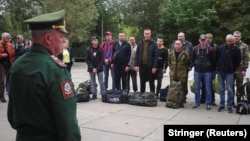 A Russian serviceman addresses reservists at a gathering point during an ongoing partial mobilization of troops, which was announced on September 21. 