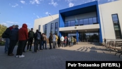 Граждане России стоят в очереди у здания миграционного центра обслуживания населения. Алматы, 3 октября 2022 года