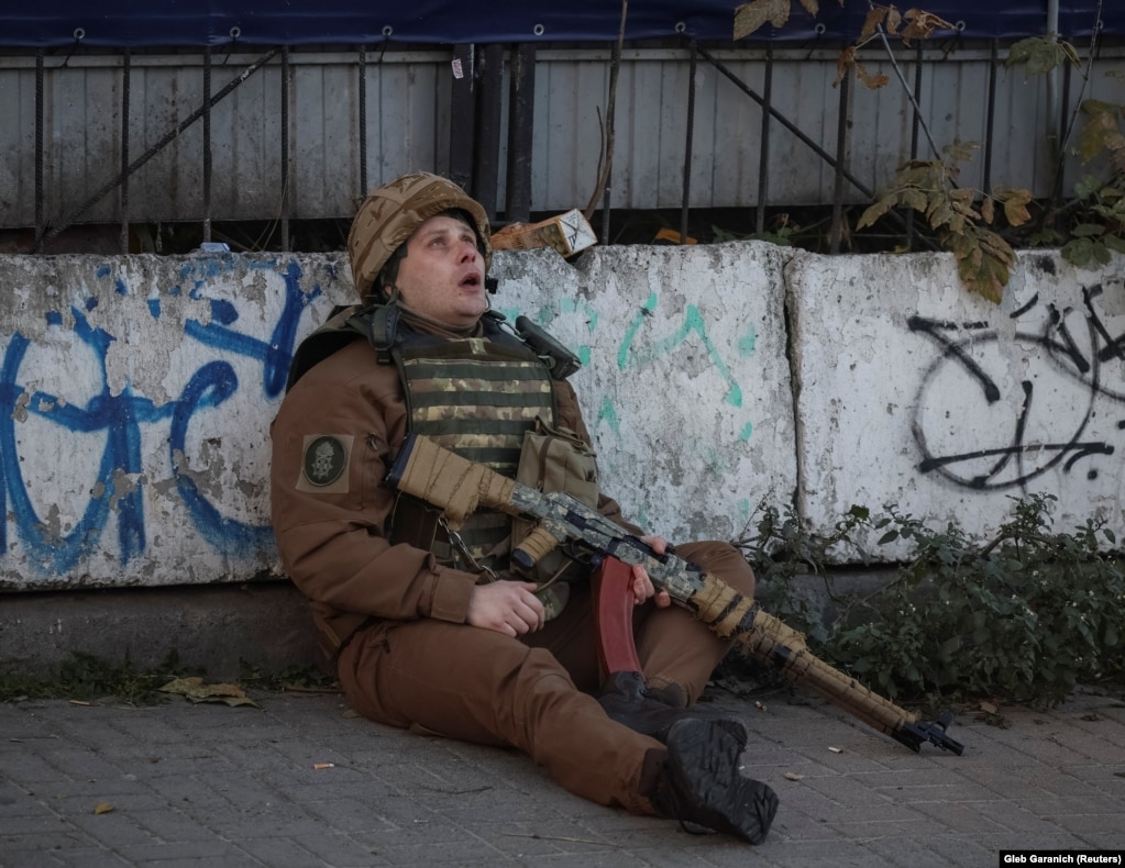 Украинский солдат всматривается в небо под звуки сирены воздушной тревоги во время удара российского беспилотника по Киеву 17 октября.