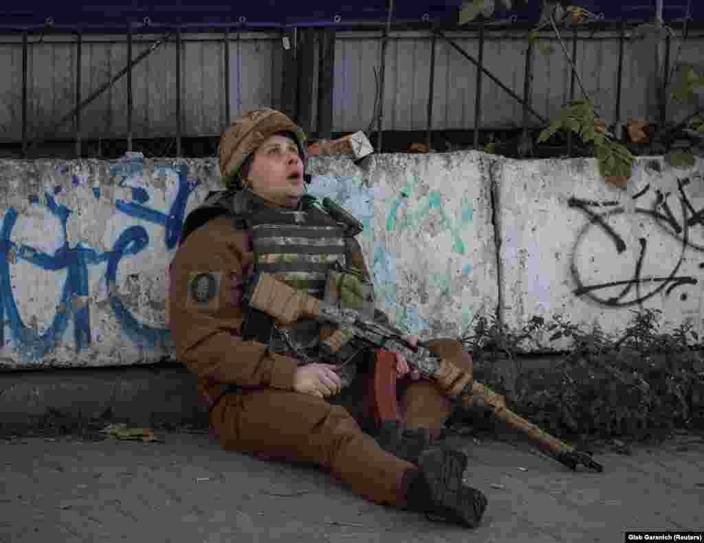 A Ukrainian soldier takes cover as an air-raid siren sounds during a Russian drone strike in Kyiv on October 17.